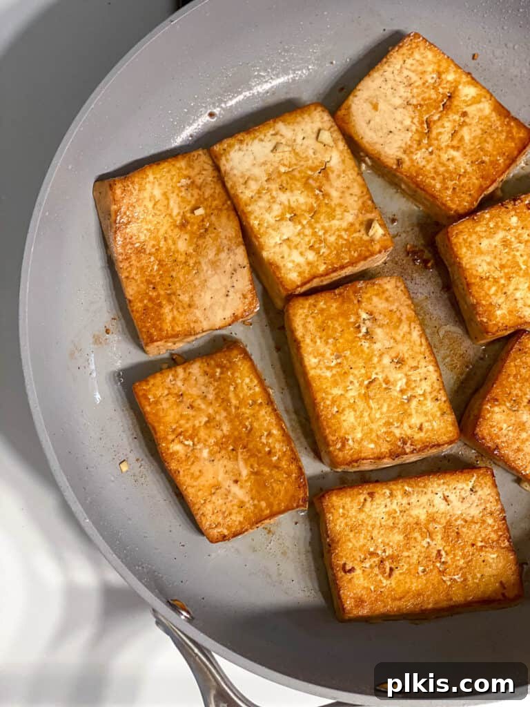Effortless Tofu Adobo 12 Process shot showing browned tofu on a skillet, flipped to the other side.