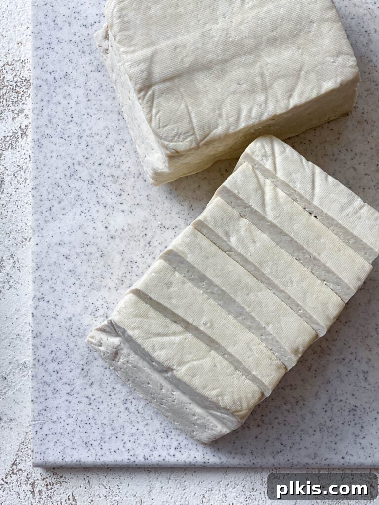 Effortless Tofu Adobo 4 Tofu block on a cutting board, ready to be prepared.