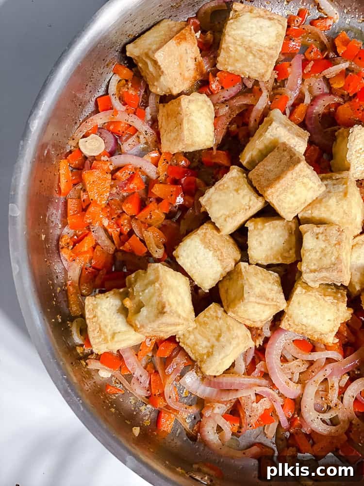 Golden Crisped Tofu Bites 8 process shot showing crispy baked tofu being added to the pan with seasoned vegetables
