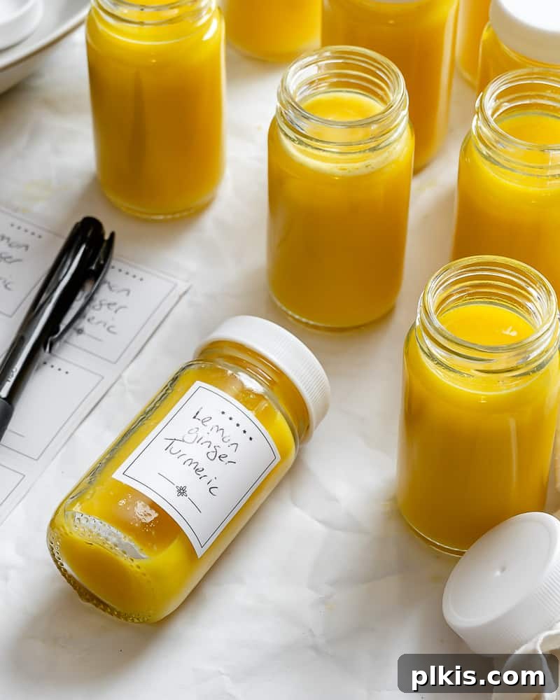 Golden Glow Immunity Booster 11 Multiple clear glass bottles filled with bright yellow Lemon Ginger Turmeric Shots, neatly arranged on a white surface, signifying freshness and health.