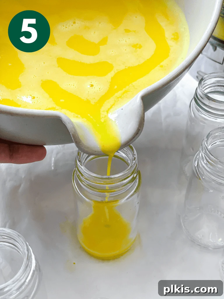 Golden Glow Immunity Booster 8 Process shot showing the vibrant liquid of Lemon Ginger Turmeric Shots being poured into individual small bottles for convenient storage and daily use.