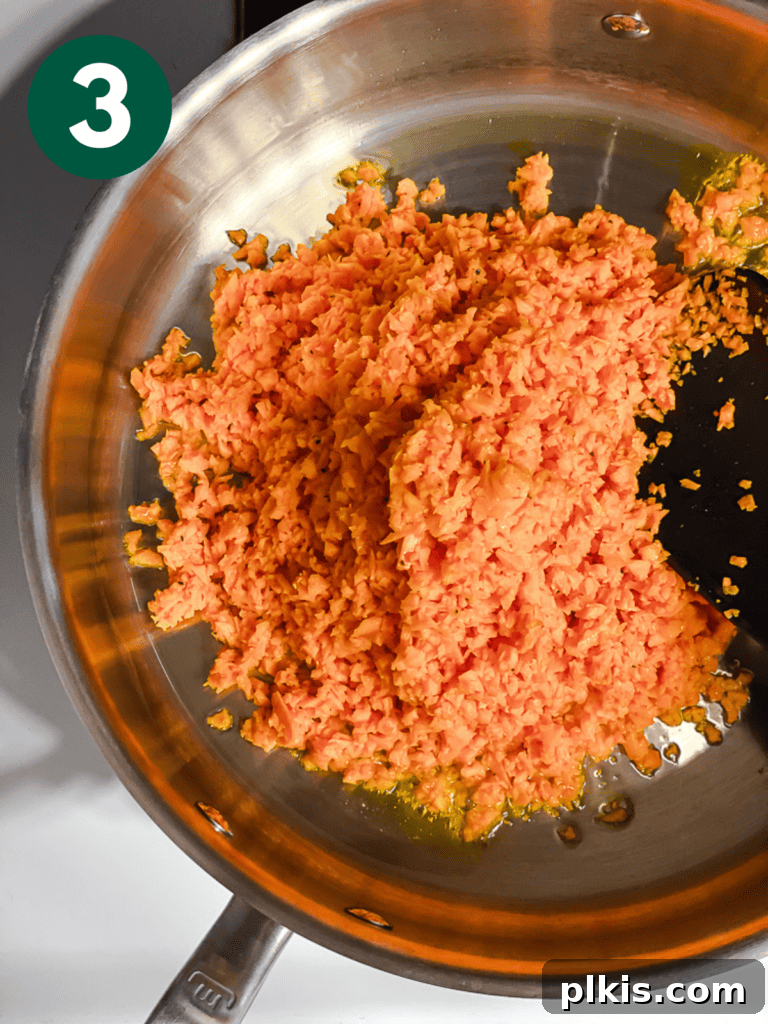 Simple Sweet Potato Rice 6 Process shot showing riced sweet potato spread evenly in a hot skillet.