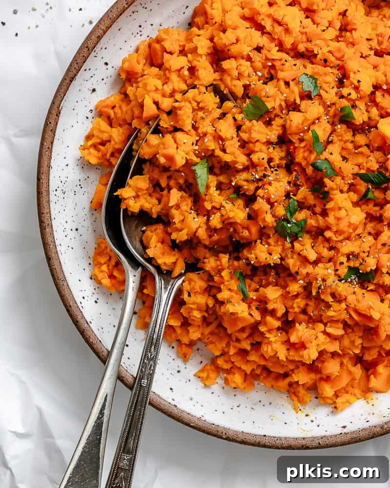 Simple Sweet Potato Rice 10 Completed Easy Riced Sweet Potato plated on a white surface, garnished with fresh herbs and ready to serve.
