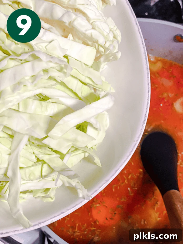 Hearty Vegan Cabbage Soup: Stove Top, Instant Pot, and Slow Cooker 12 Process shot: Adding freshly shredded green cabbage to the pot, ready to soften and cook down into the delicious soup.