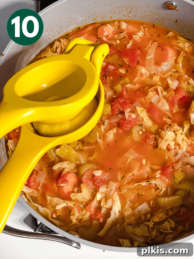 Hearty Vegan Cabbage Soup: Stove Top, Instant Pot, and Slow Cooker 13 Process shot: Squeezing fresh lemon juice into the finished cabbage soup to brighten the flavors before serving.