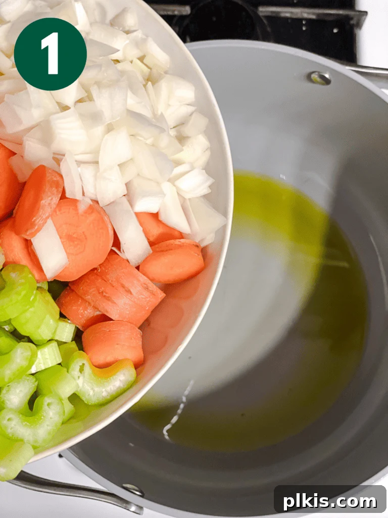 Hearty Vegan Cabbage Soup: Stove Top, Instant Pot, and Slow Cooker 4 Process shot: Adding chopped carrots, onion, and celery to a hot pan with oil, beginning the sautéing process for the soup base.