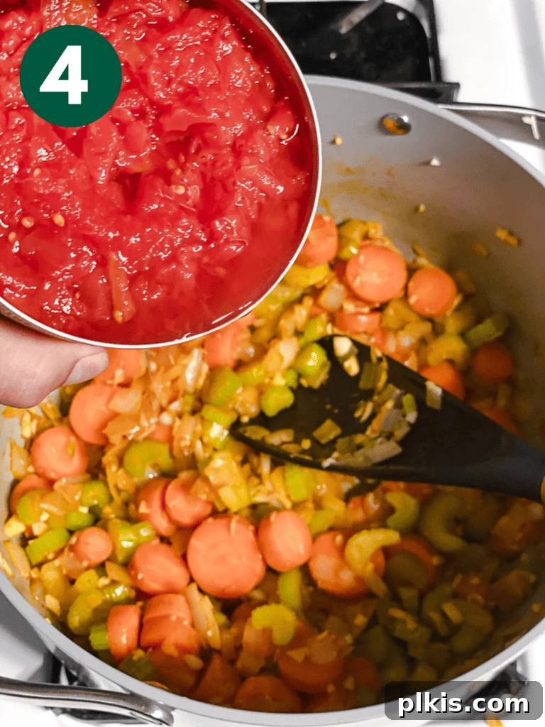 Hearty Vegan Cabbage Soup: Stove Top, Instant Pot, and Slow Cooker 7 Process shot: Pouring canned diced tomatoes into the sautéed vegetable mixture, adding a rich red base to the soup.