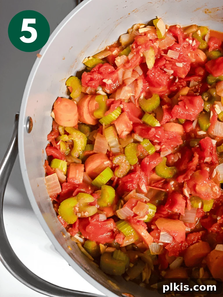 Hearty Vegan Cabbage Soup: Stove Top, Instant Pot, and Slow Cooker 8 Process shot: The vibrant tomato and vegetable mixture simmering gently in the pot, developing deep flavors for the cabbage soup.