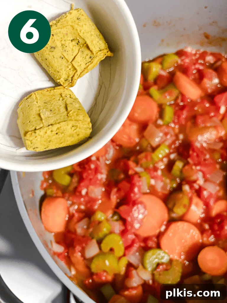 Hearty Vegan Cabbage Soup: Stove Top, Instant Pot, and Slow Cooker 9 Process shot: Adding vegetable bouillon cubes to the pot, ready to dissolve and flavor the soup base.