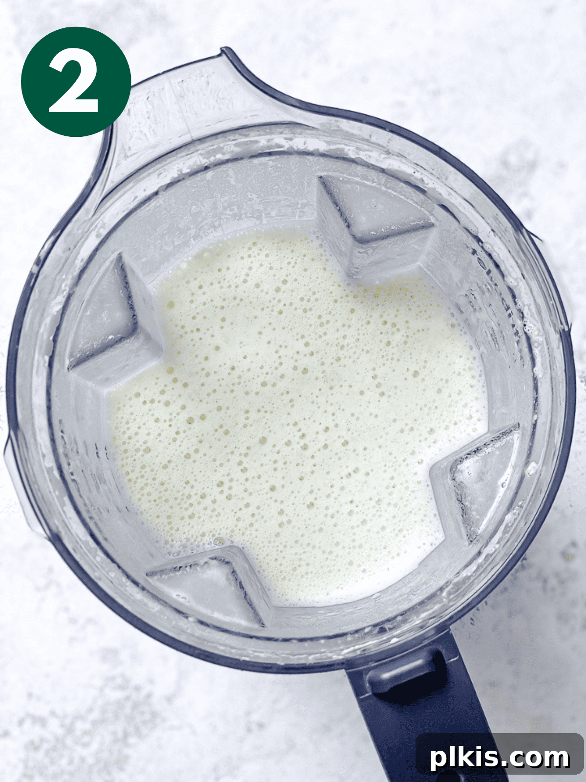 Plant-Based Alfredo Bliss 5 blended vegan alfredo sauce in a blender.