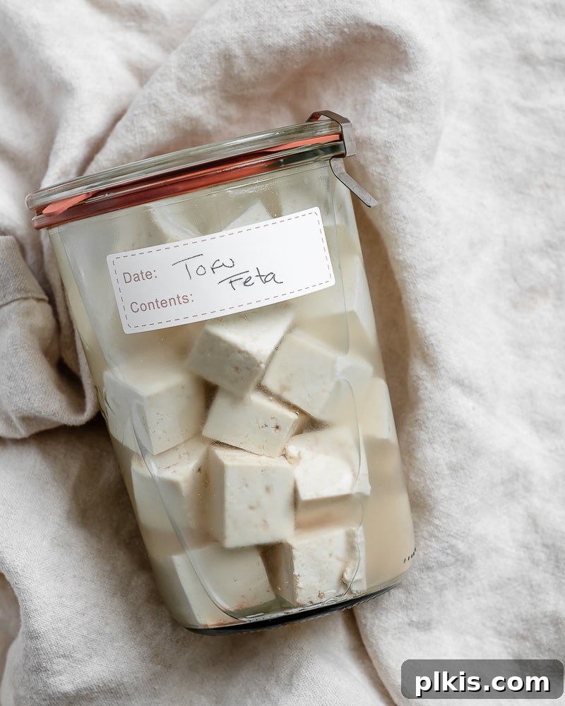 Completed Tofu Feta Cheese beautifully arranged in a glass jar, ready for use