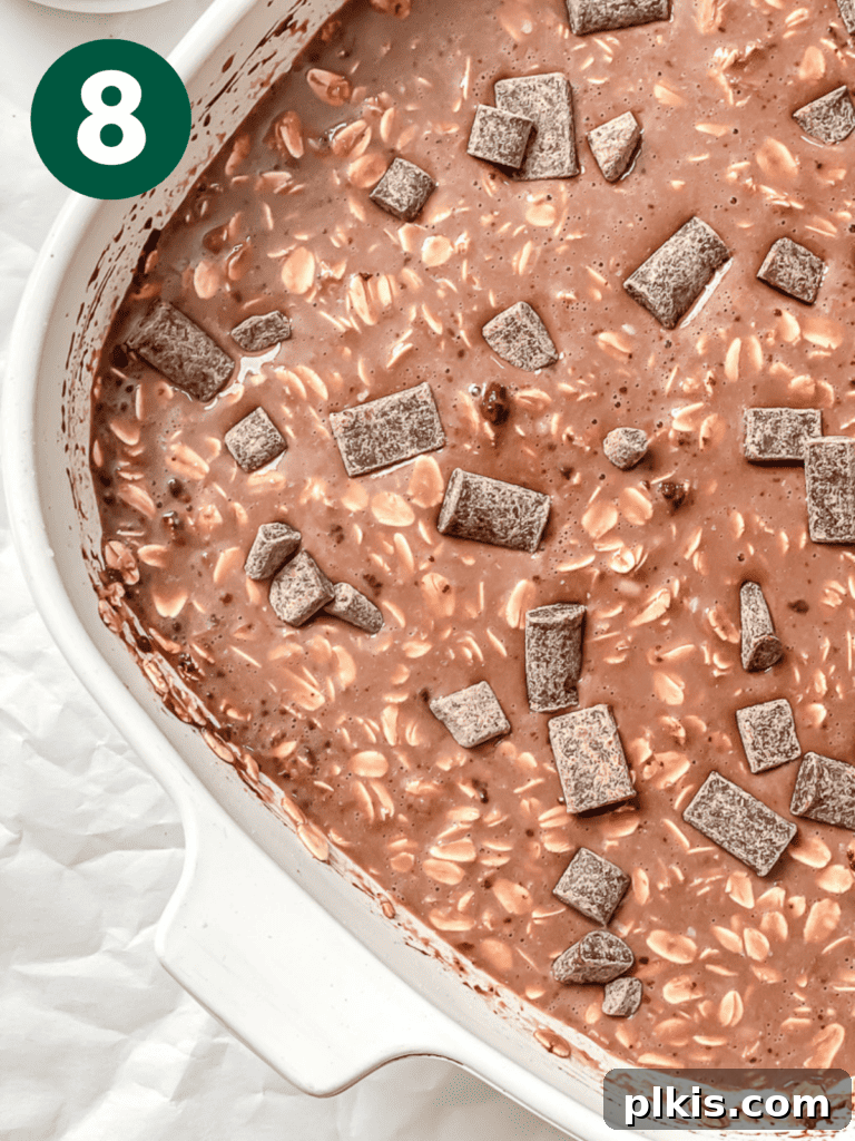 Decadent Chocolate Baked Oats: Smooth or Hearty 11 Process shot showing vegan chocolate chunks pressed into the top of the oat mixture before baking