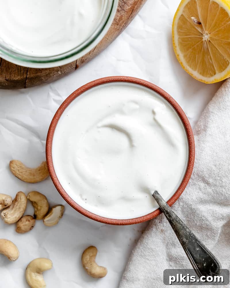 Silky Cashew Cream 2 creamy white cashew cream in a small bowl, garnished with a sprinkle of herbs.