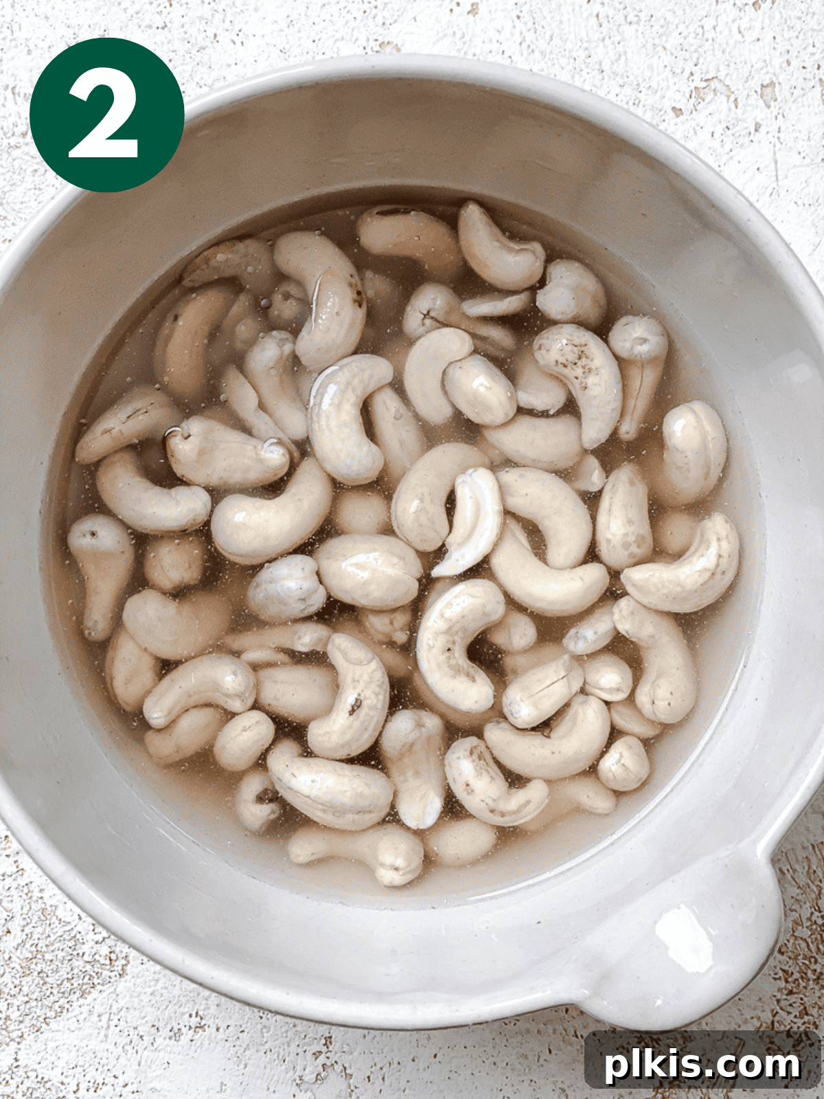 Silky Cashew Cream 5 drained, soaked cashews in a large white bowl, ready for blending.