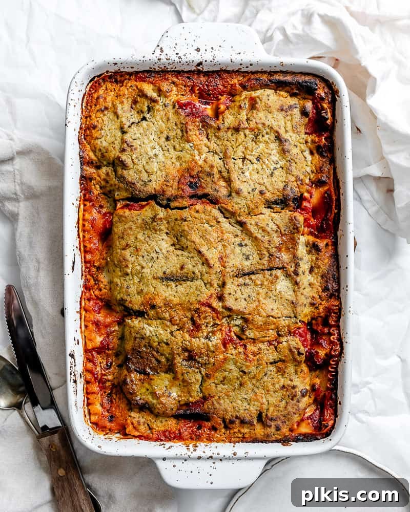 Hearty Vegan Eggplant Lasagna 2 A freshly baked vegan eggplant lasagna, golden brown and bubbling in a ceramic baking dish, ready to be served.
