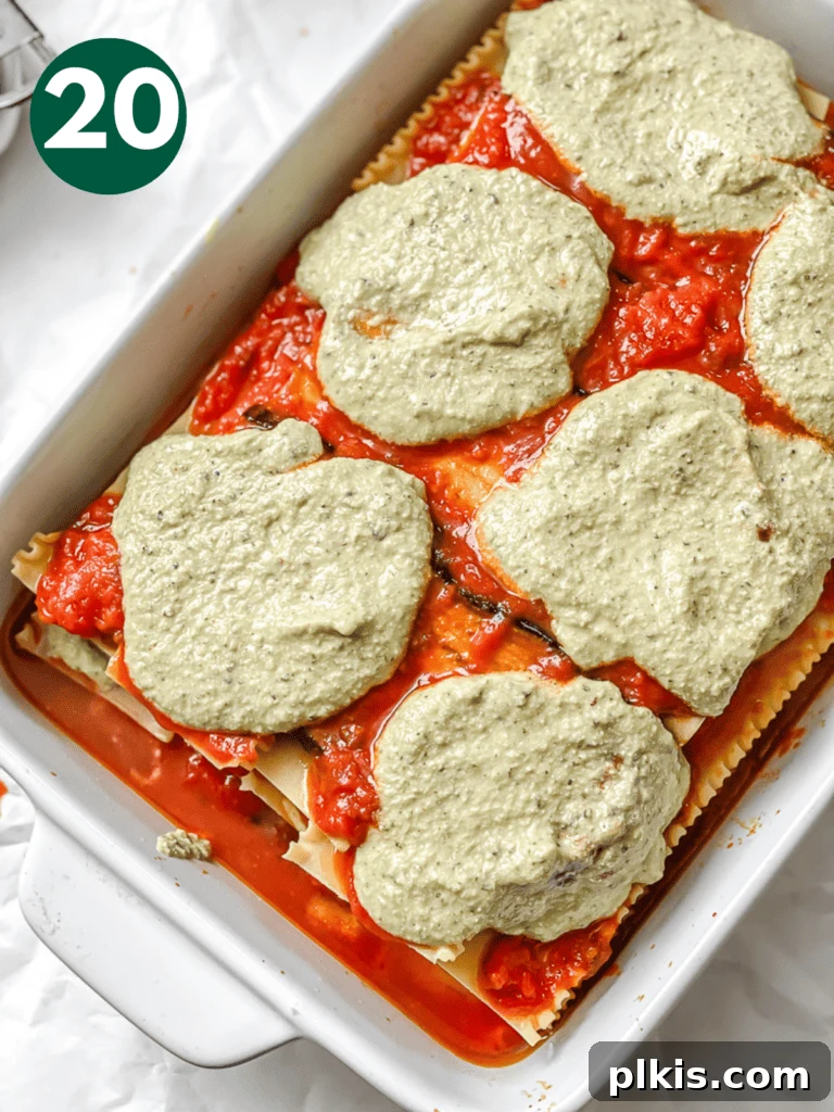 Hearty Vegan Eggplant Lasagna 23 Creamy dollops of the final tofu ricotta layer spread across the top of the partially assembled vegan eggplant lasagna.