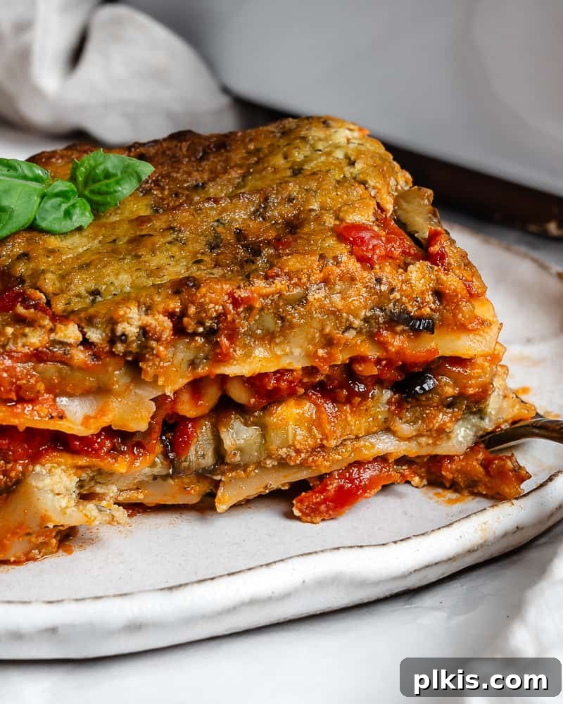 Hearty Vegan Eggplant Lasagna 26 A mouthwatering slice of vegan eggplant lasagna, layered with tender eggplant, creamy tofu ricotta, and rich tomato sauce, served on a white plate.
