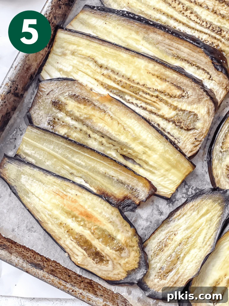 Hearty Vegan Eggplant Lasagna 8 Roasted eggplant slices, beautifully golden and tender, cooling on a baking sheet after emerging from the oven.