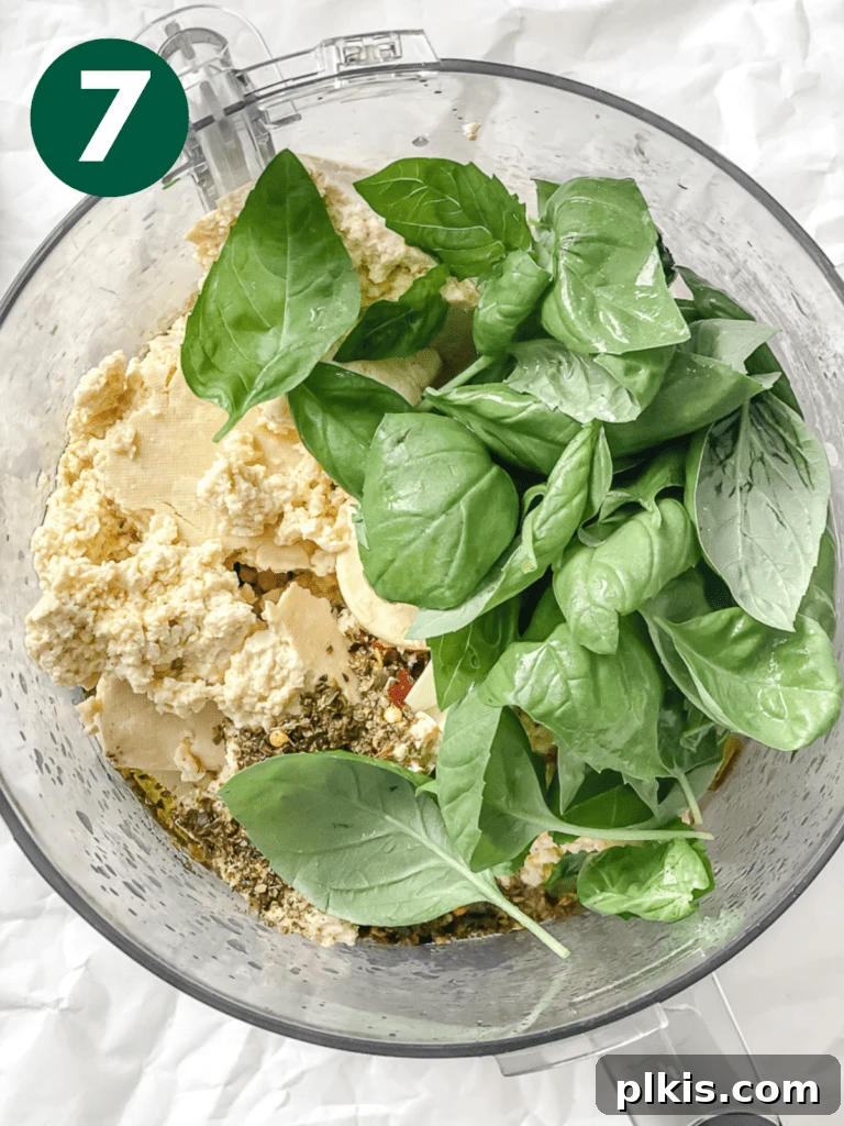 Hearty Vegan Eggplant Lasagna 10 Various tofu ricotta ingredients, including extra-firm tofu, fresh basil, and garlic, prepared for blending in a food processor.