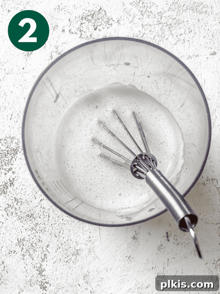 Plant-Powered Irish Soda Bread 5 Process shot of whisking vegan milk and vinegar in a cup.