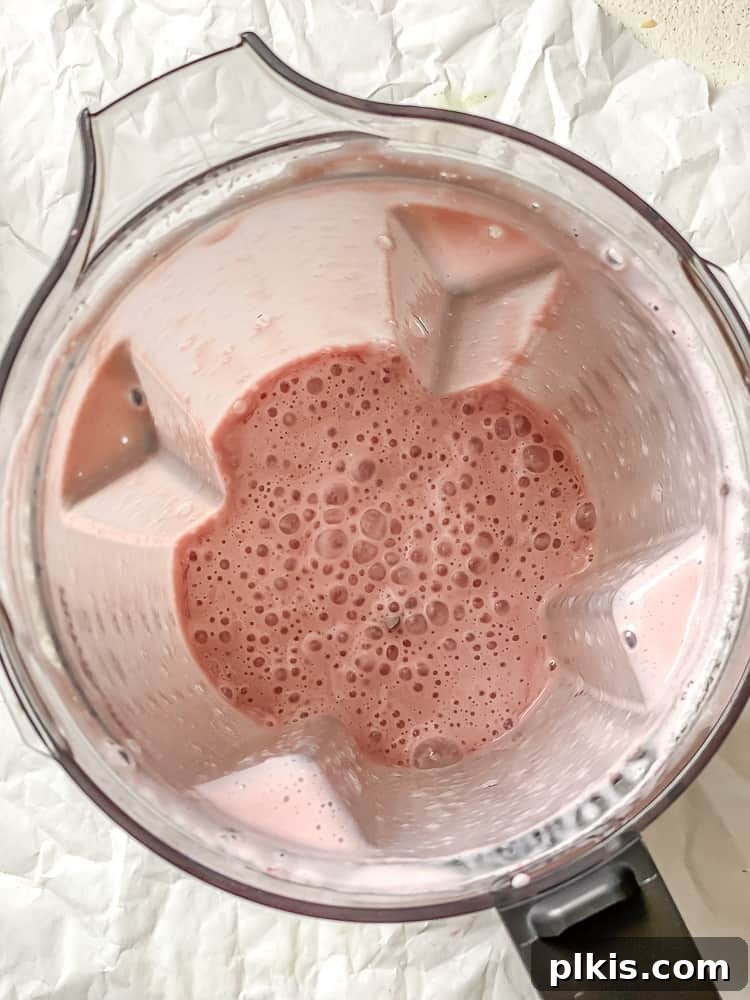 Process shot showing post blended strawberry milk in blender.