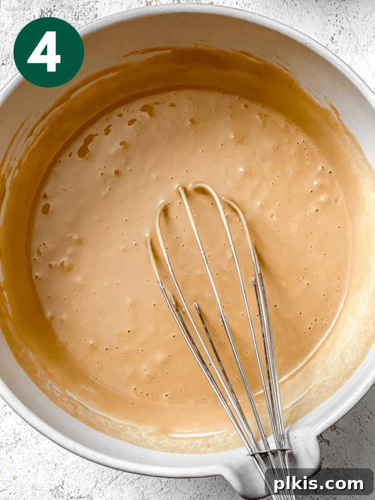 Effortless Coffee Cupcakes 7 The vegan coffee cupcake batter continuing to be mixed in a bowl, reaching a smooth and consistent texture.