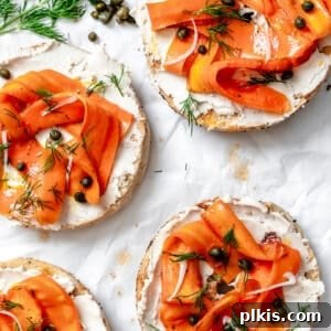 completed Carrot Lox [Vegan Smoked Salmon] spread out on bagel halves on a white surface