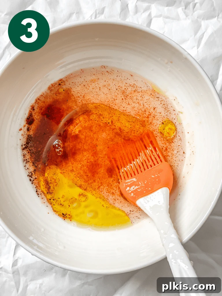 Smoky Carrot Lox 6 A process shot demonstrating the mixing of the marinade ingredients – water, olive oil, rice vinegar, lemon juice, smoked paprika, and black pepper – in a small white bowl.