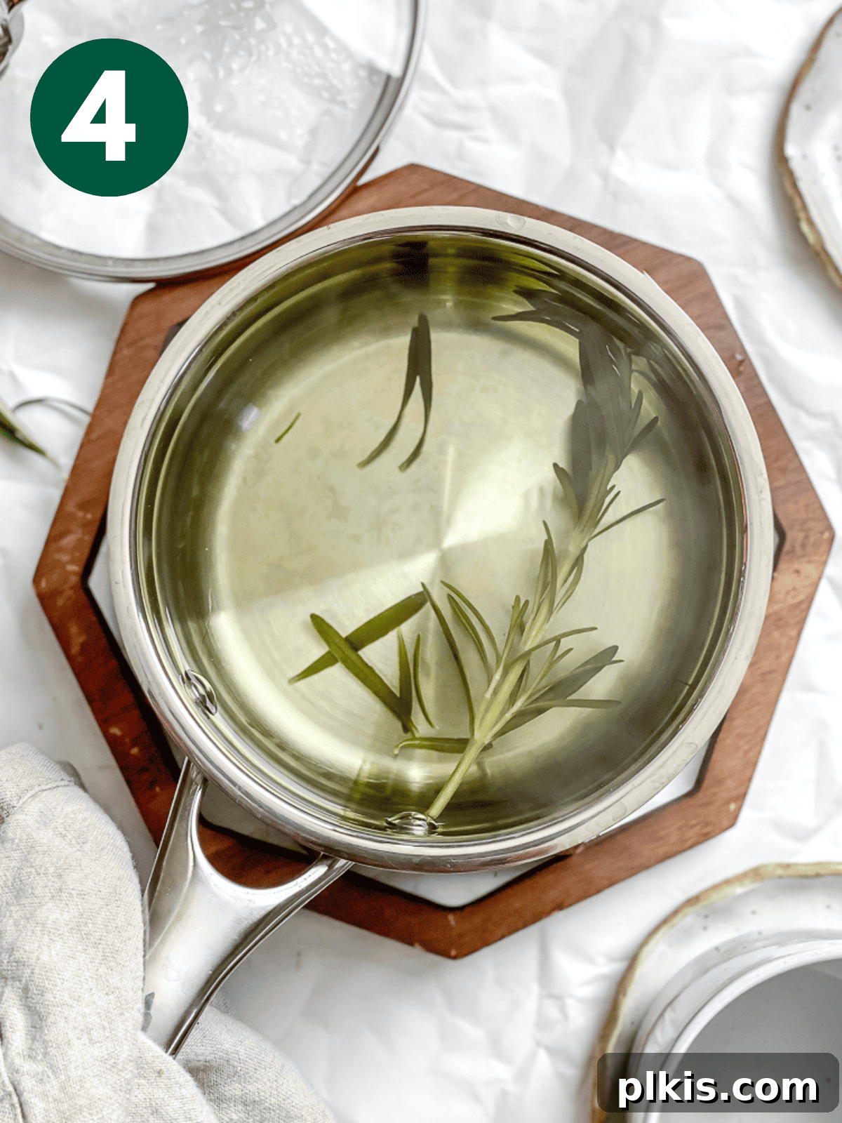 Rosemary's Evergreen Elixir 7 Steeped rosemary sprigs in a pot of rosemary tea, with steam gently rising.