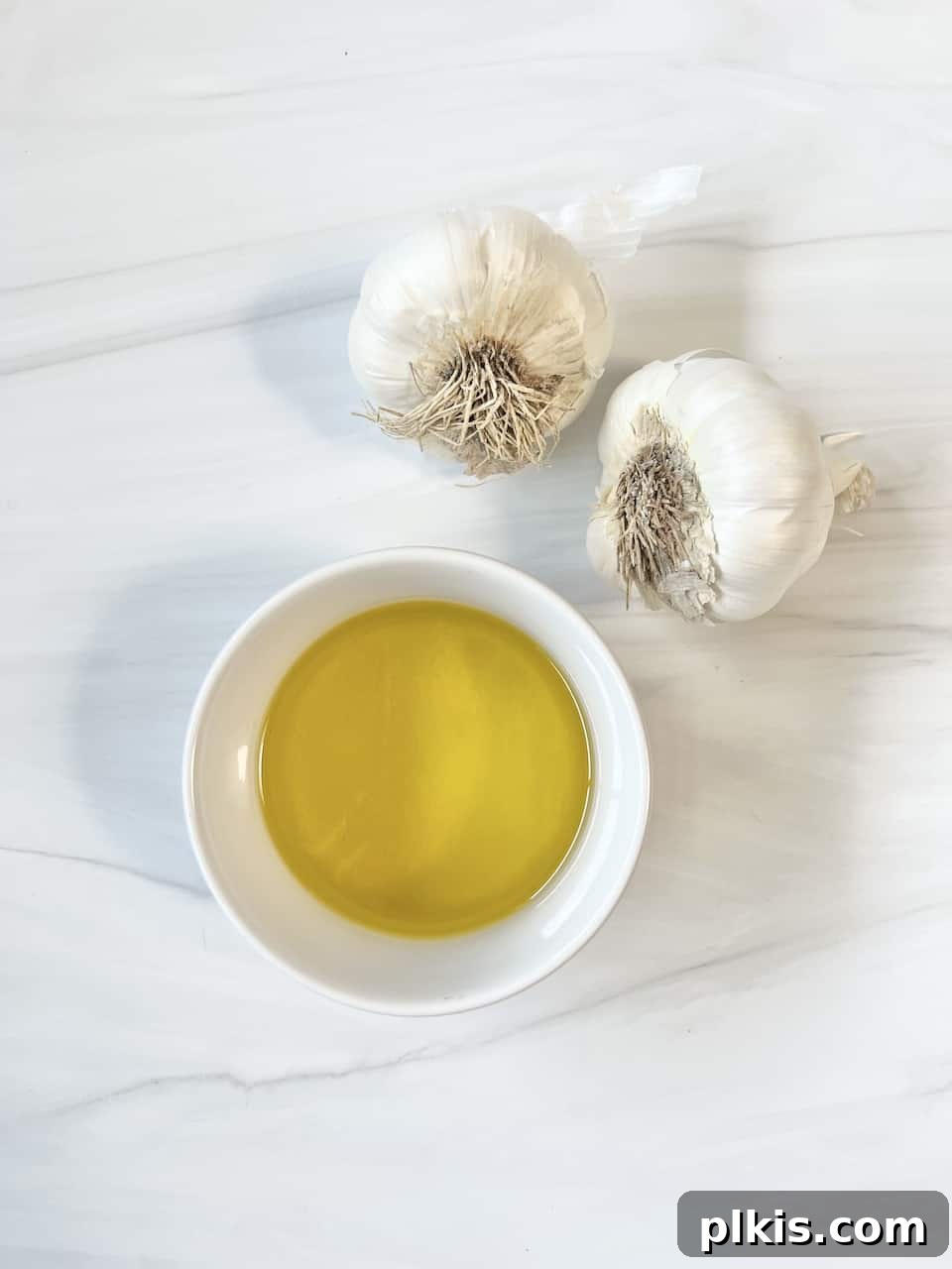 Stovetop Garlic Duo: Pan-Roasted & Confit 3 ingredients for Stovetop Roasted Garlic against a white marble surface