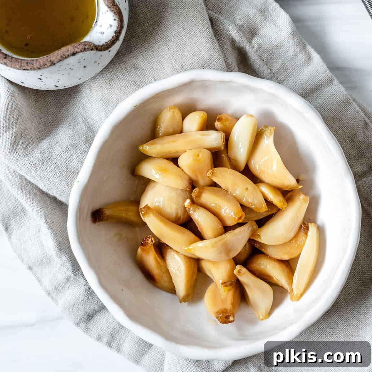 Stovetop Garlic Duo: Pan-Roasted & Confit 8 completed Stovetop Roasted Garlic in a white bowl against a white background
