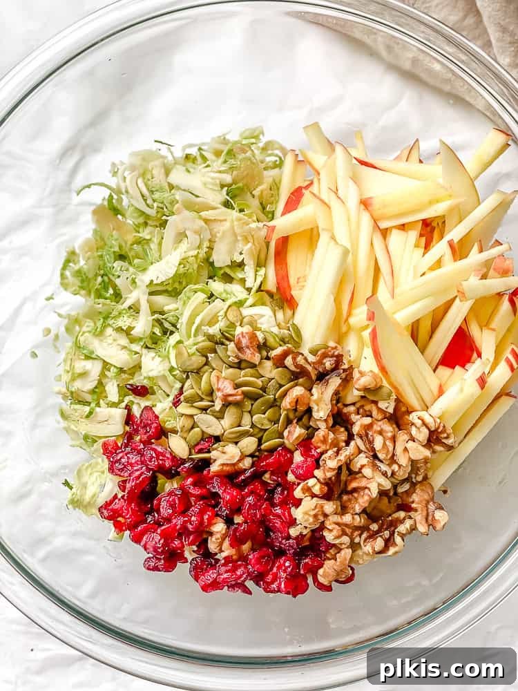 Process shot showing ingredients for a Shaved Brussels Sprouts Salad in a large glass bowl.