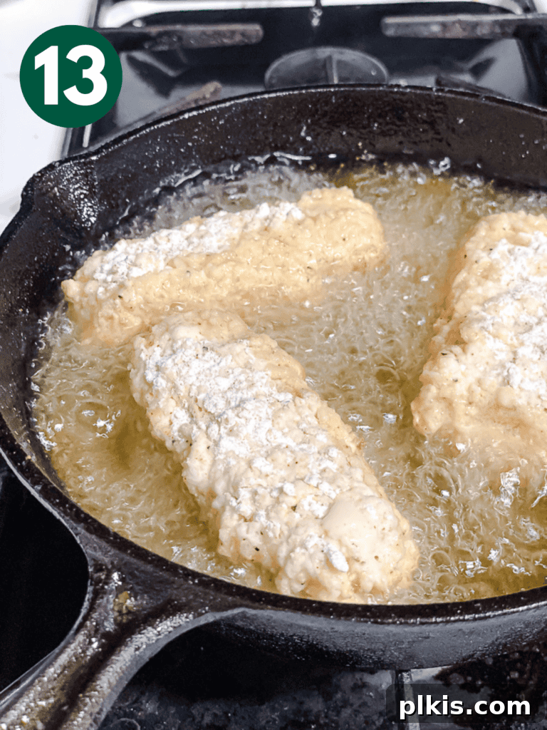 Crispy Tofu Chicken 16 process shot showing tofu being carefully added to hot oil in a pan