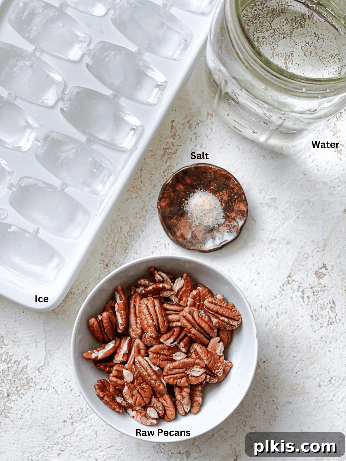 All the measured ingredients for making homemade pecan milk laid out on a clean white surface.