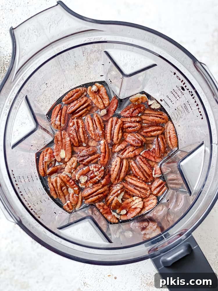 Raw pecans and water in a high-speed blender, ready for blending.