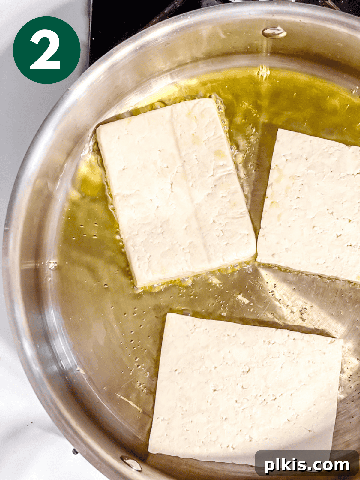 Chipotle Spiced Tofu 5 frying tofu slices in a large metal pan.