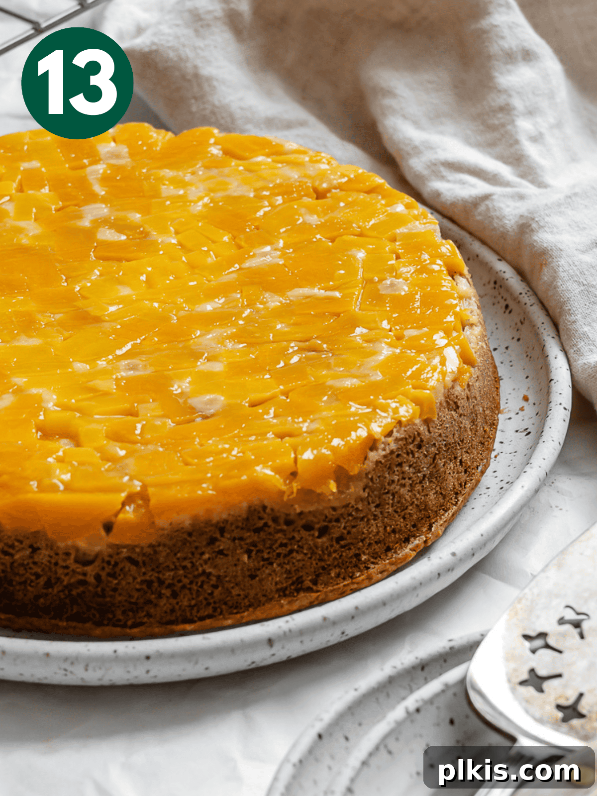Tropical Mango Delight 16 a baked mango cake on a white plate after being flipped.