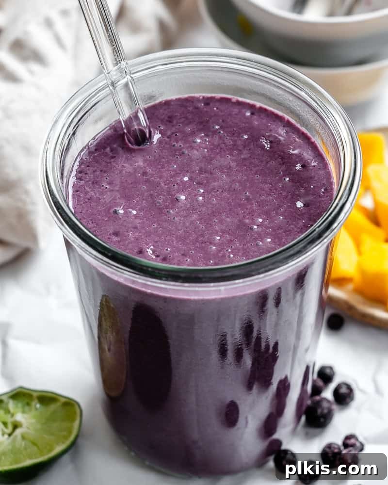 Vibrant Mango Berry Bliss 2 Vibrant Mango Blueberry Smoothie in a glass, ready to be enjoyed.