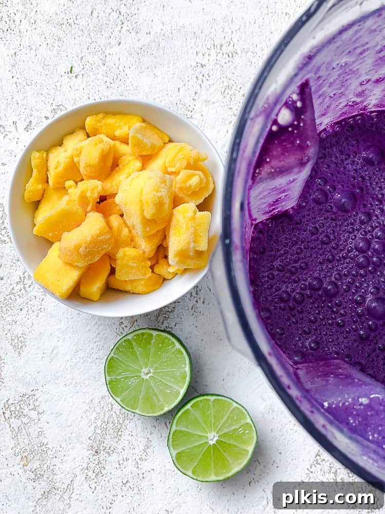 Vibrant Mango Berry Bliss 5 Fresh mango and lime next to a blender, ready for the next step of smoothie preparation.