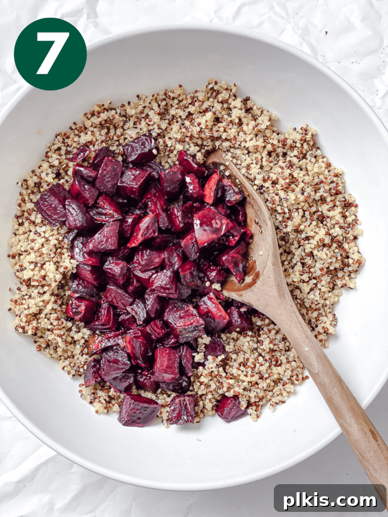 Vibrant Roasted Beet & Quinoa Medley 10 Process shot showing roasted beets being added to a large salad bowl with quinoa.