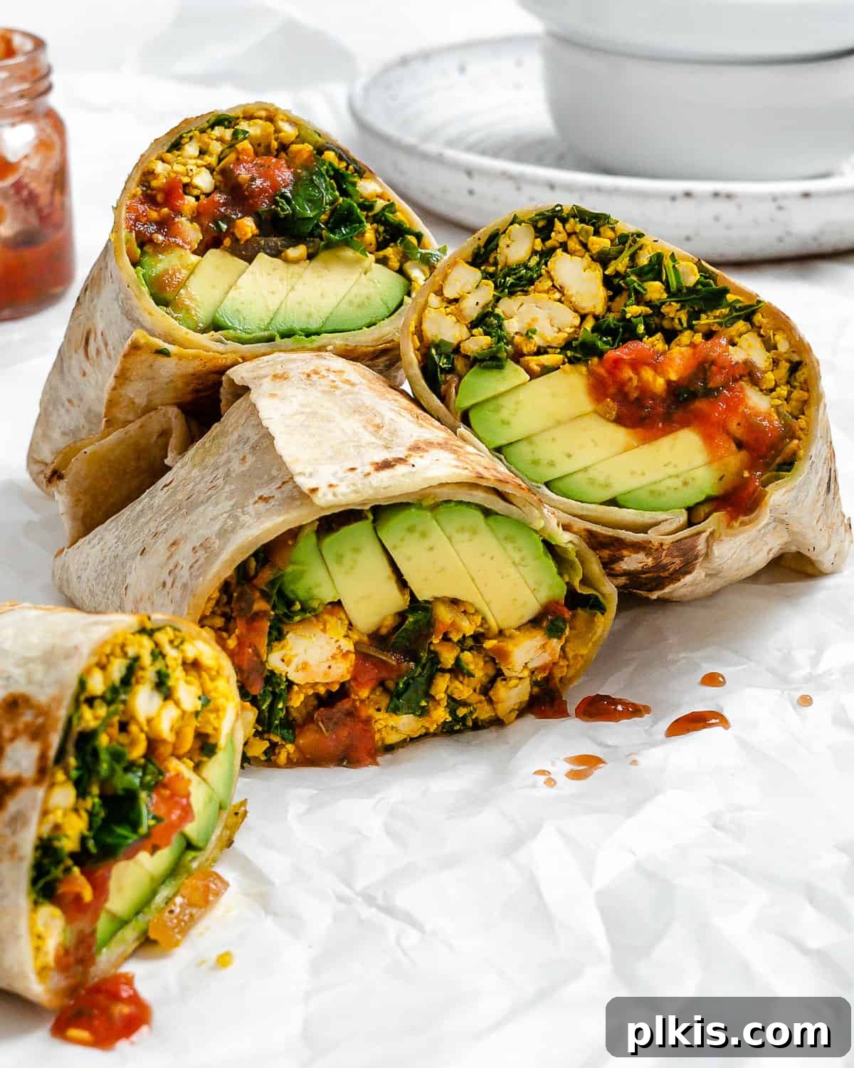 Effortless Plant-Based Breakfast Wrap 12 completed Easy Scrambled Tofu Breakfast Burritos on a white surface