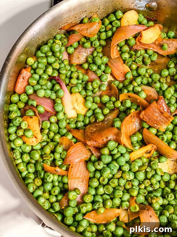 Emerald Pea Pasta 5 Process shot illustrating green peas added to the pot with the sautéed aromatics and seasonings, gently cooking to blend flavors.