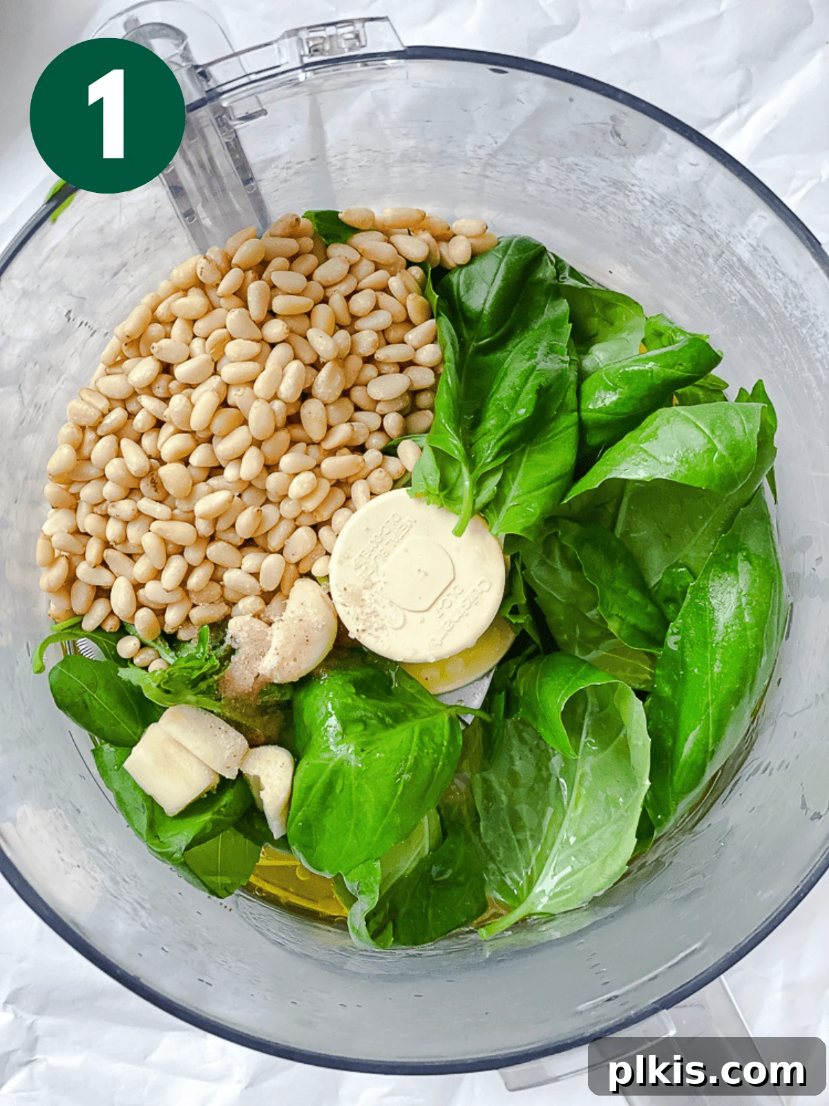 All ingredients for vegan pesto placed in a food processor, ready for blending.