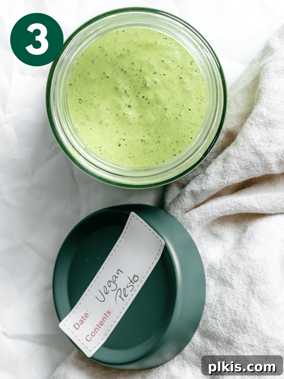 Vegan pesto stored in a glass container with a lid.