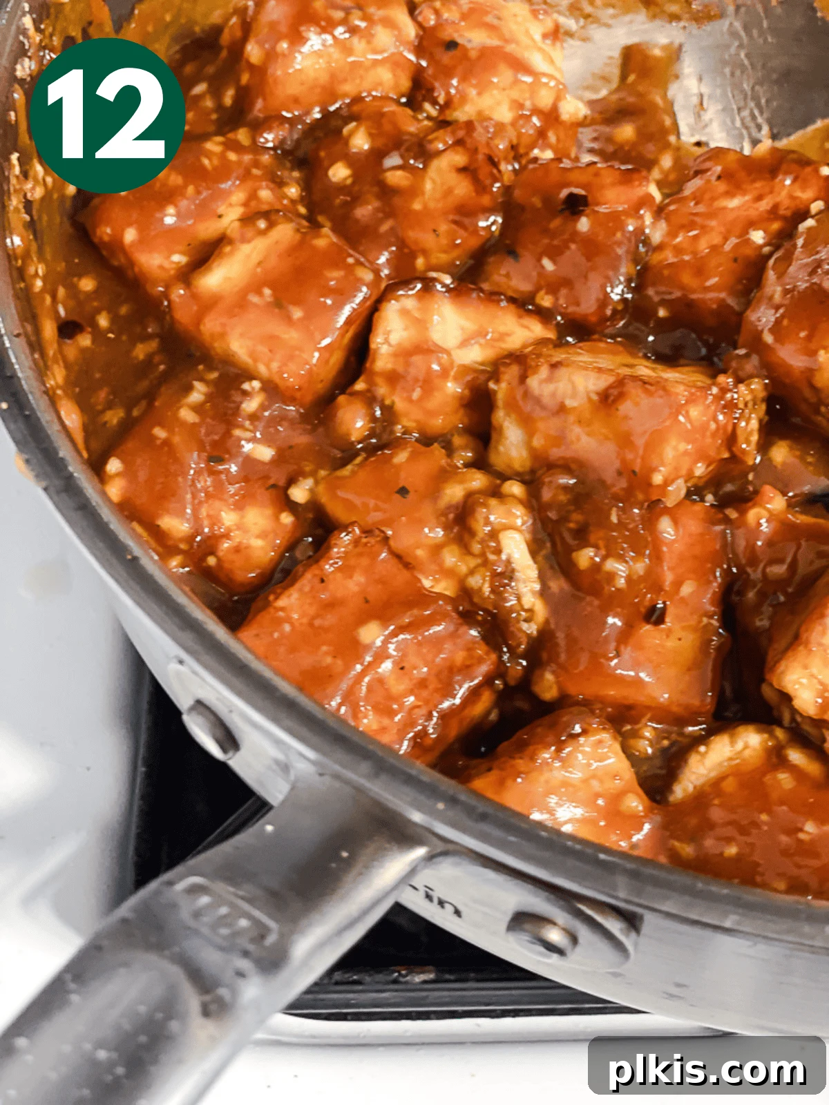 Crispy Tangy Tofu Delight 15 Close-up of General Tso's tofu coated in sauce in a large metal pan, ready to serve.