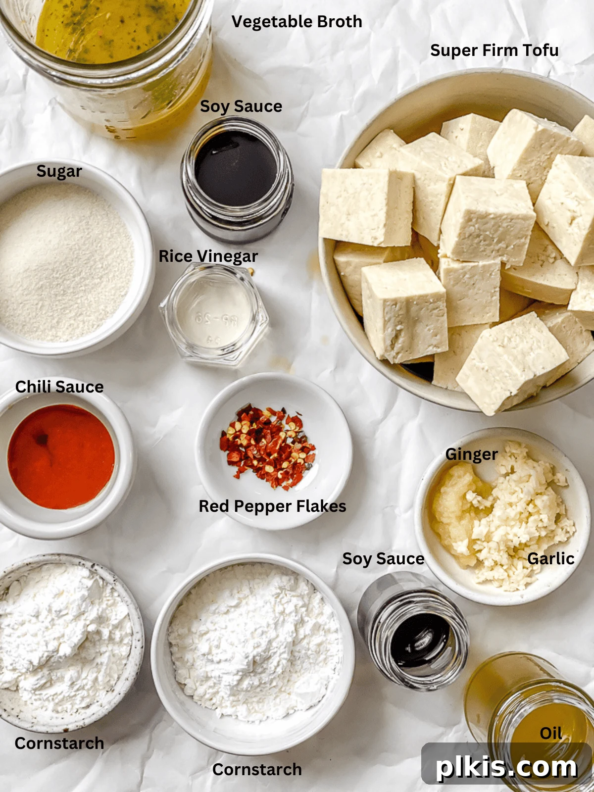 Crispy Tangy Tofu Delight 3 Individual white bowls showcasing ingredients for General Tso's tofu: vegetable broth, soy sauce, sugar, rice vinegar, chili sauce, cornstarch, tofu, oil, ginger, garlic, and red pepper flakes.