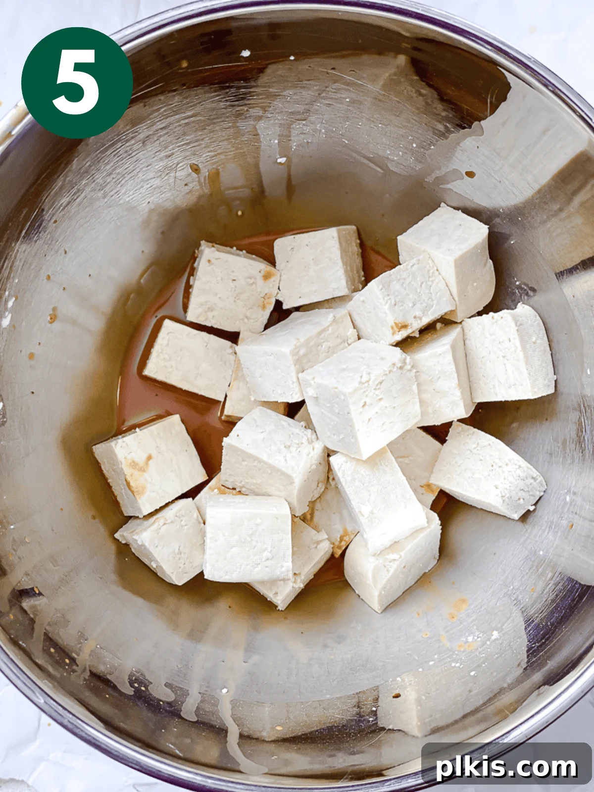 Crispy Tangy Tofu Delight 8 Tossing cubed tofu in a soy sauce and cornstarch mixture to coat evenly.