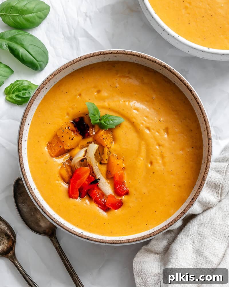 Velvety Roasted Butternut and Red Pepper Soup 2 A beautifully presented bowl of creamy Roasted Butternut Squash Red Pepper Soup, garnished and ready to serve.