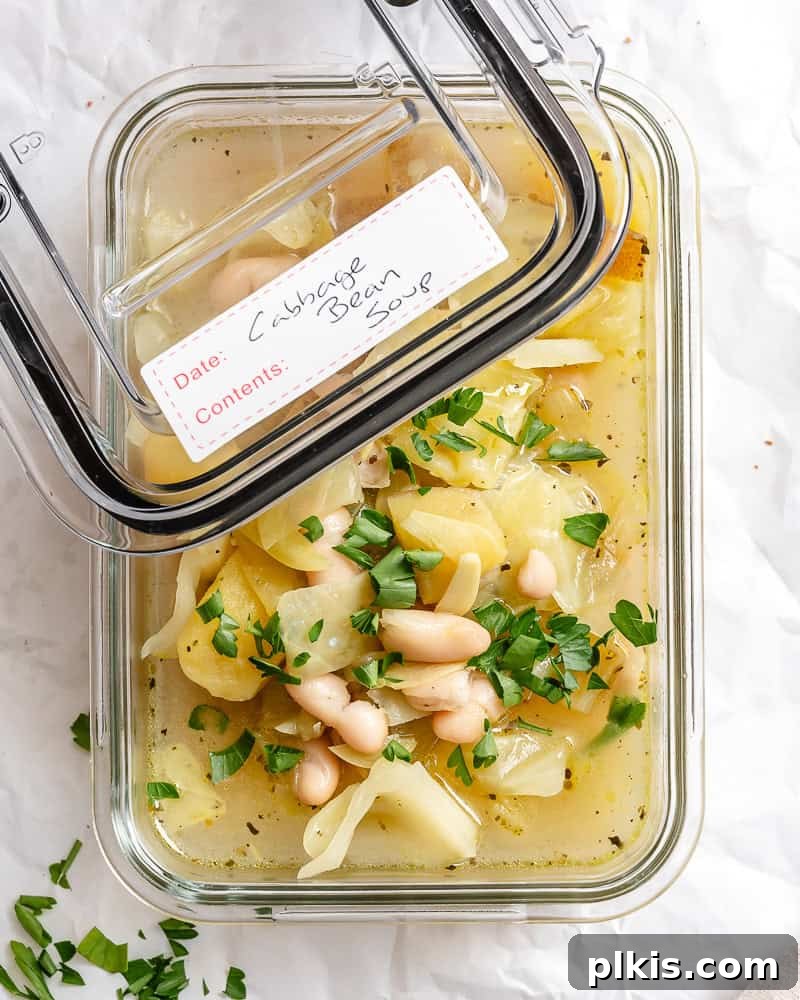 Rustic Cabbage and Bean Pot 9 Cabbage Bean Soup stored in a transparent meal prep container, ready for refrigeration or freezing.