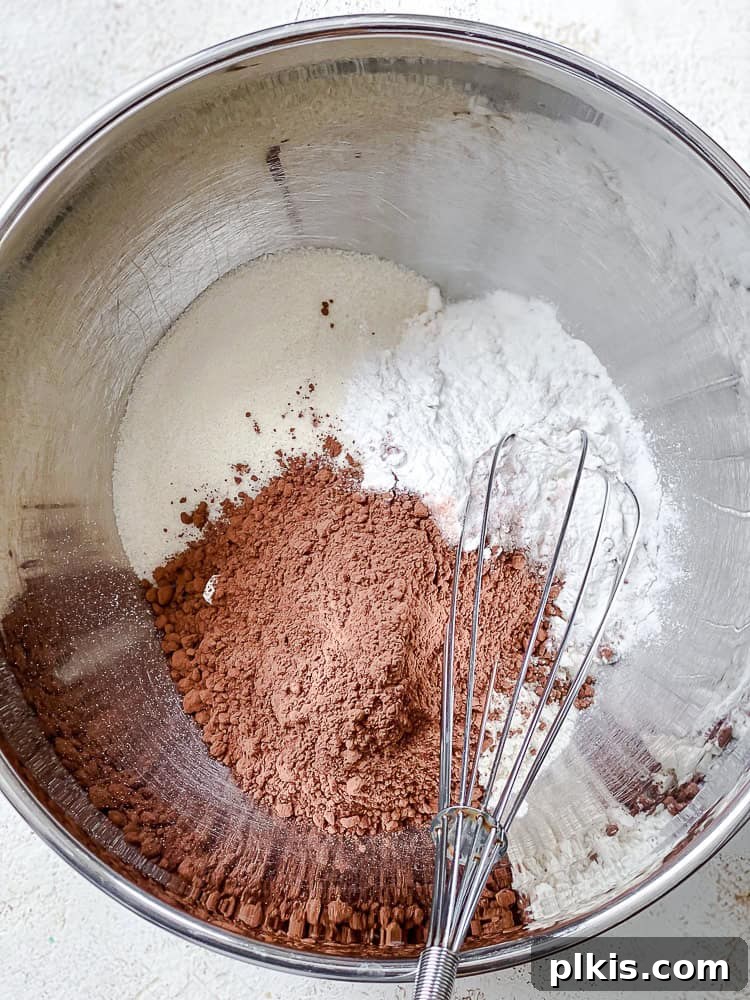 Decadent Double Chocolate Muffins 4 Process shot of dry ingredients being whisked together in a large mixing bowl.